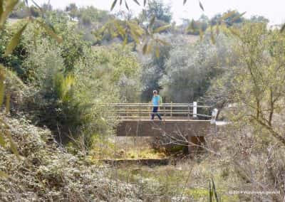 Wandelaar op brug over droge rivierbedding Pechão wandelroute