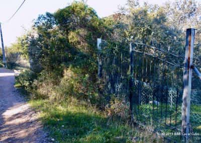 Overwoekerd ijzeren hek langs wandelroute Cerro da Goldra