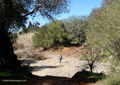 Wandelaar steekt de rivierbedding van de Algibre over op rondwandeling LLE PR14